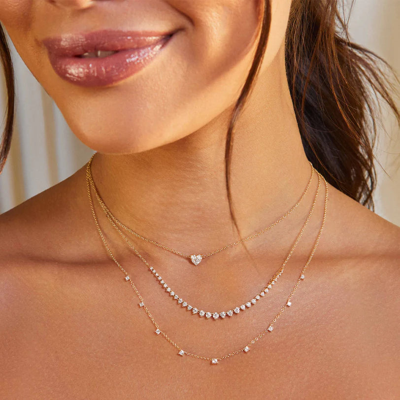 EF Collection 9 Prong Set Diamond Necklace in yellow gold on models neck layered with diamond necklaces.