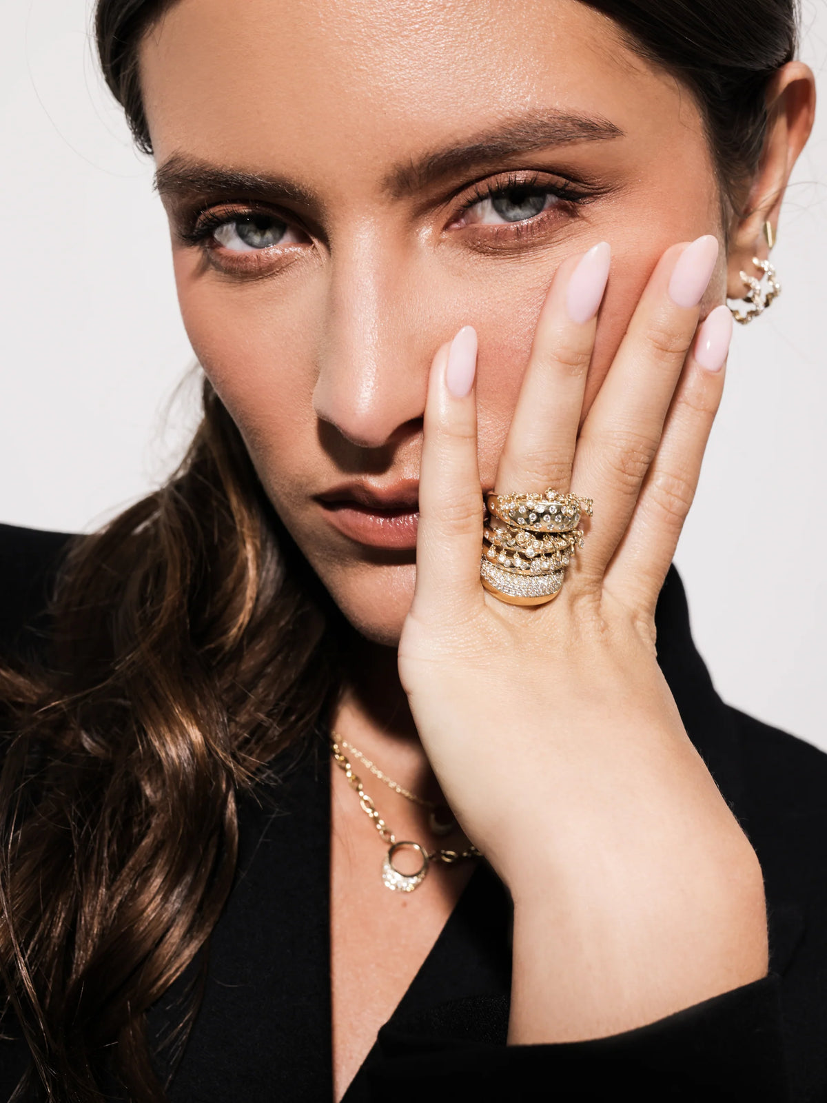close up of model wearing Onirikka Caviar Ring in polished 14k yellow gold with 0.46ctw bezel-set diamonds — elegant gold ring with dangling diamonds.