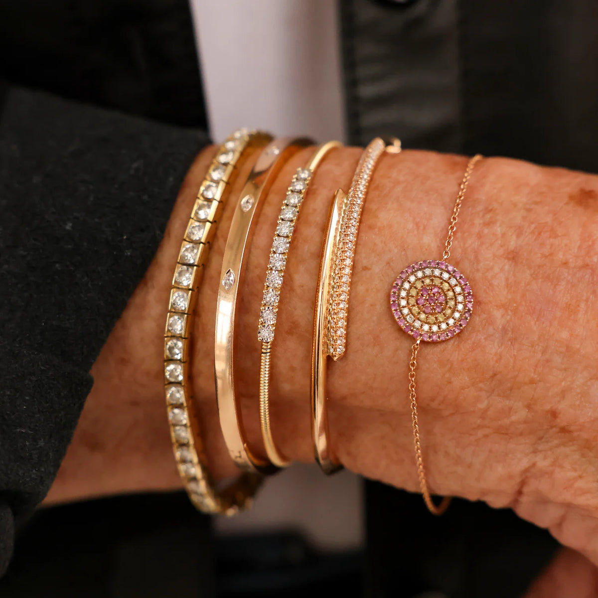 Dana Rebecca Designs Ava Bea Flexi Cuff Bracelet in yellow gold styled on models wrist wearing a black jacket