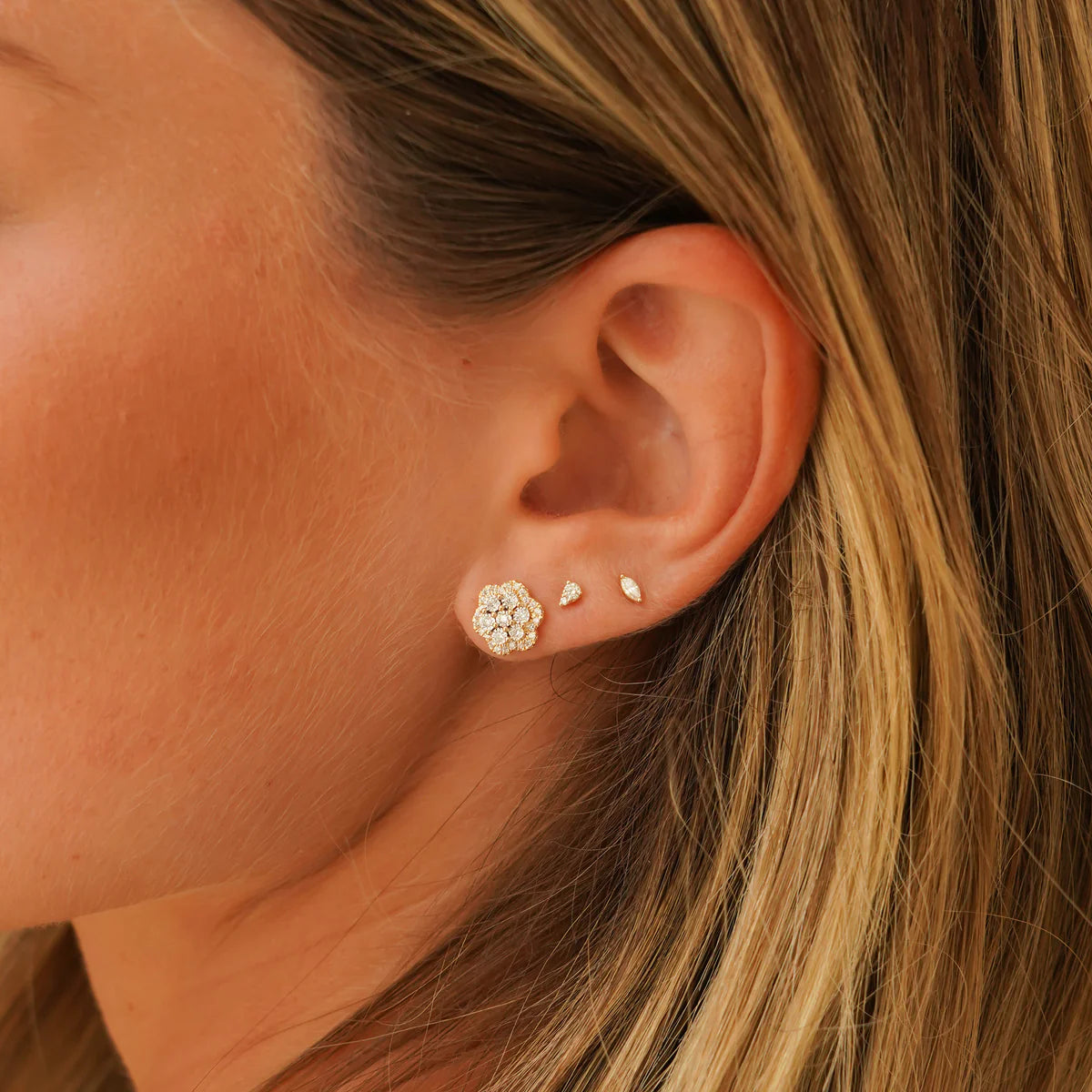 close up of Ava Bea Flower Studs in yellow Gold styled on an ear