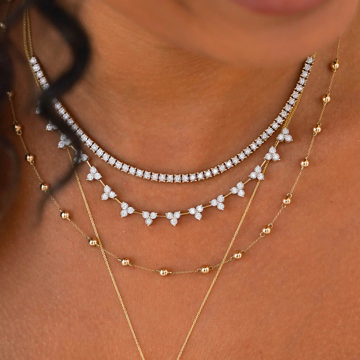 Dana Rebecca Designs Ava Bea Interval Trio Tennis Necklace in yellow gold styled on models neck with ava bea tennis necklace