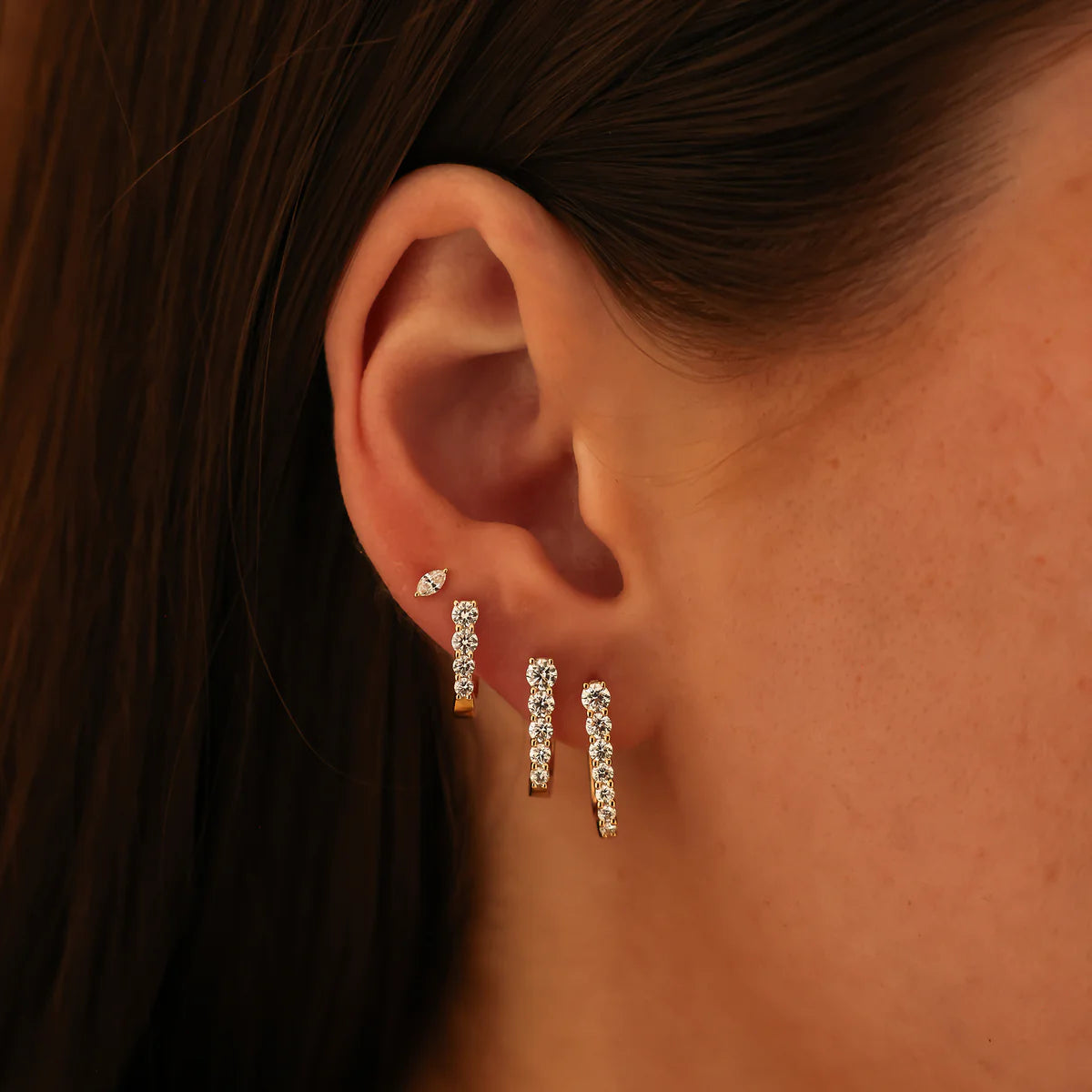 close up of Ava Bea Medium Graduating Hoop in Yellow Gold styled on model's ear