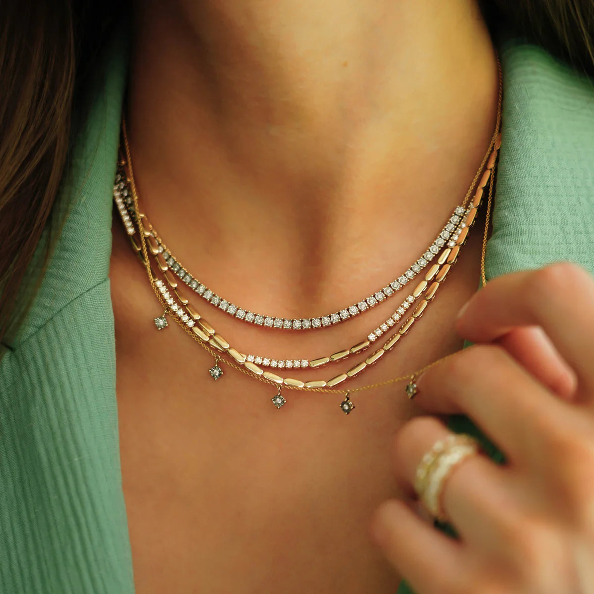 Close up of model layering Dana Rebecca Designs Ava Bea Station Necklace in Yellow Gold