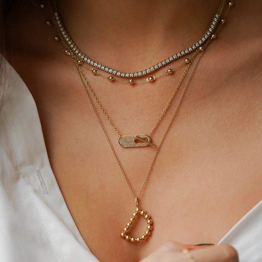 Dana Rebecca Designs Ava Bea Tennis Necklace in yellow gold styled on models neck wearing a white shirt