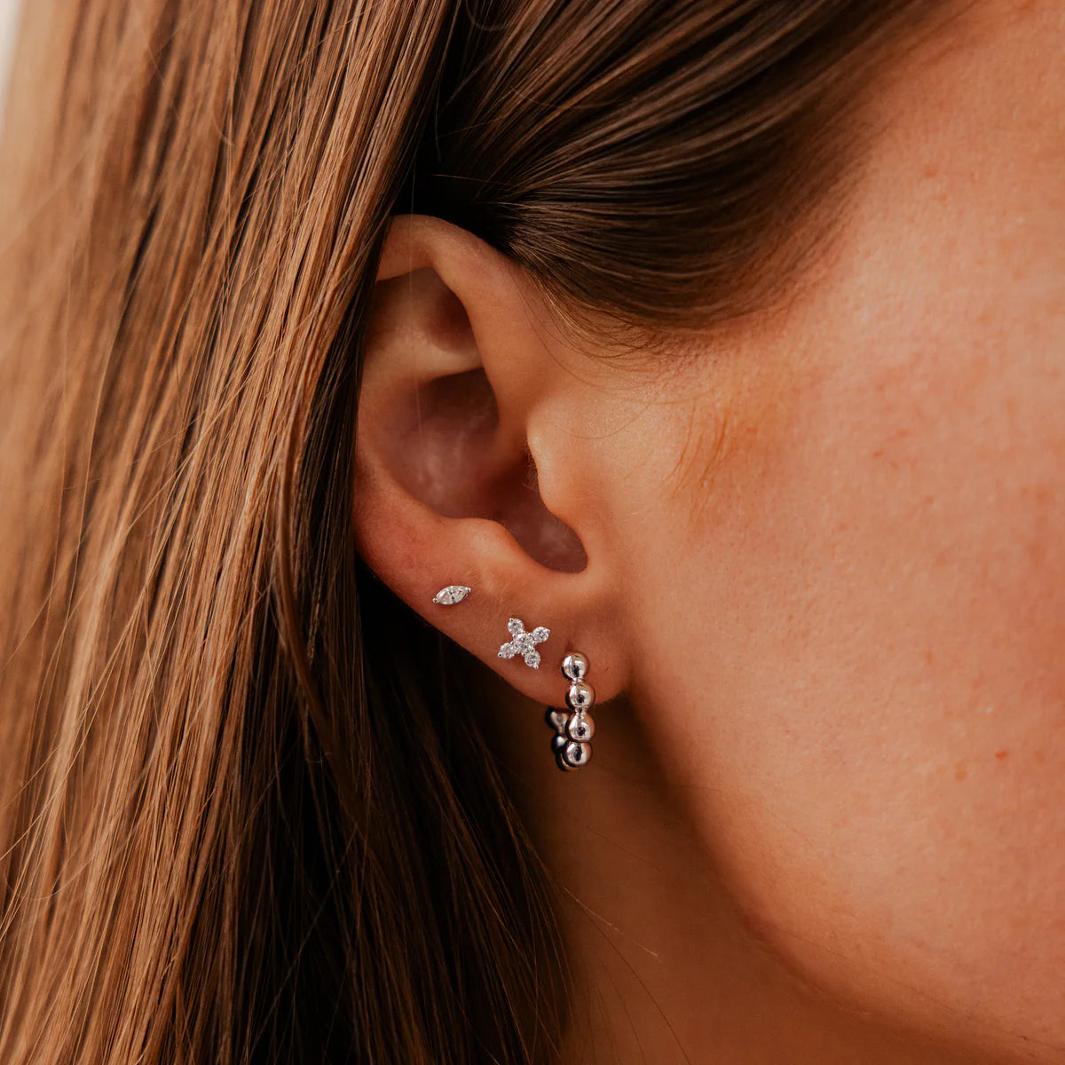 close up of Ava Bea X Studs in White Gold stacked on model