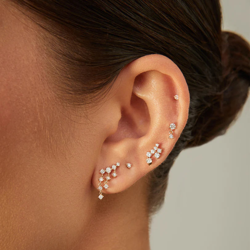 EF Collection Baby Solitaire Diamond Stud Earring in yellow gold styled on models ear.