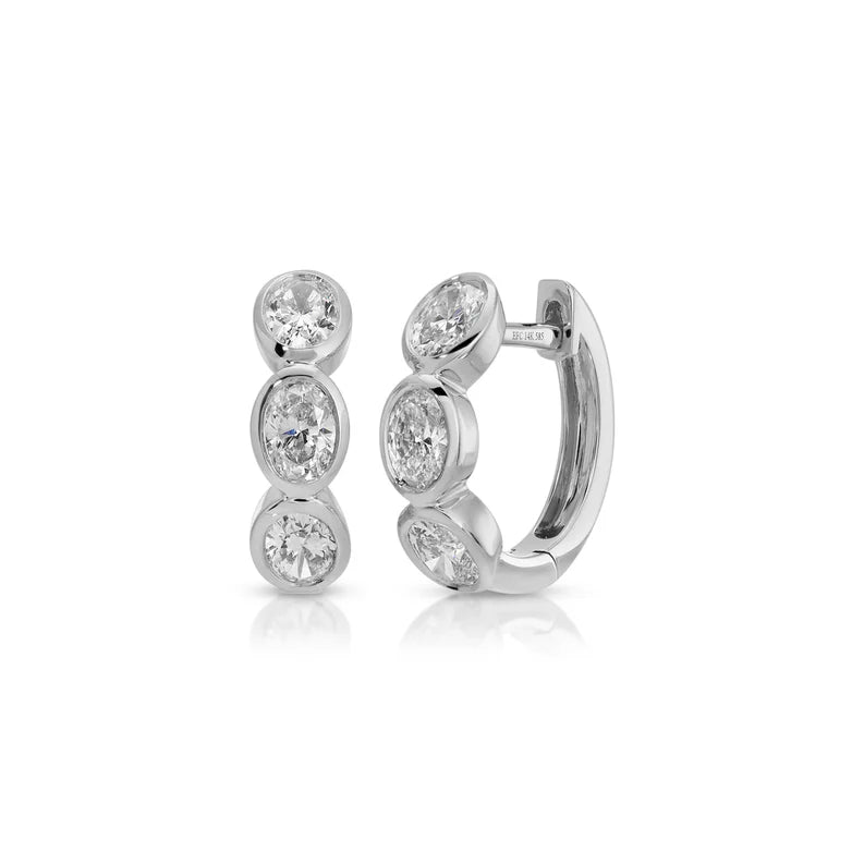 EF Collection Bezel Set Oval Diamond Huggie Earrings in white gold on white background