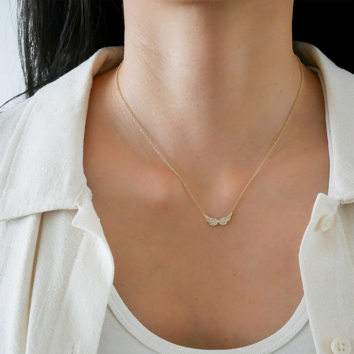 Close up of single EF-Collection Diamond Double Angel Wing Necklace in yellow gold on models neck
