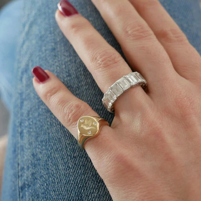 Close up of EF Collection Diamond Hummingbird Signet Ring in yellow gold on model’s finger.