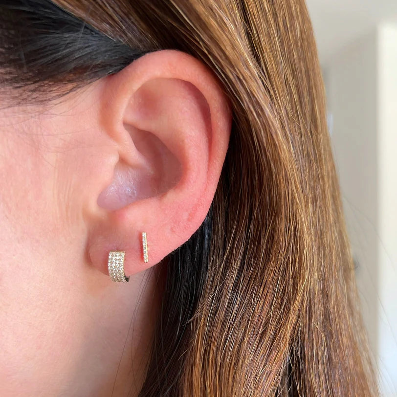 EF-Collection Diamond Jumbo Huggie Earrings in yellow gold on models ears styled with a yellow gold diamond bar.