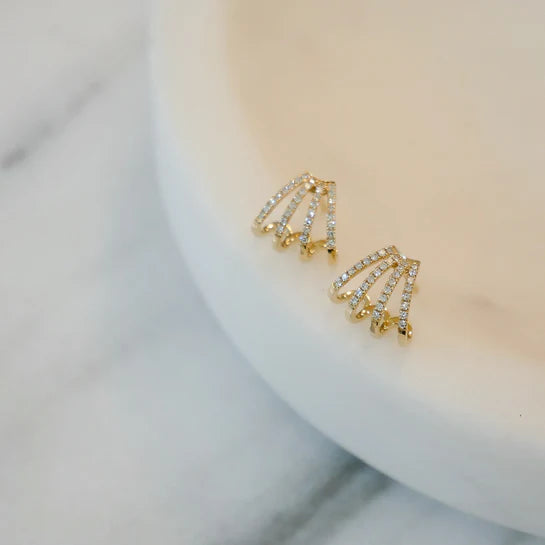 EF-Collection Diamond Multi Huggie Earrings in yellow gold styled on a white plate