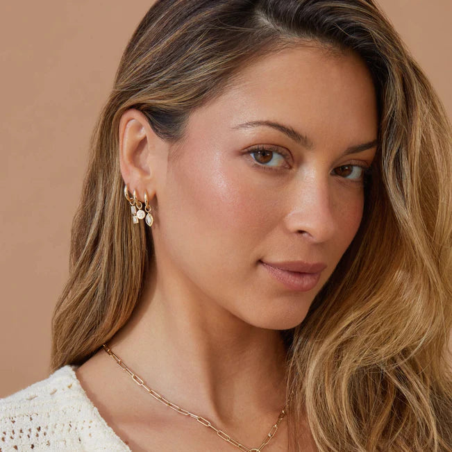 EF Collection Gold Frame Marquise Diamond Huggie Charm on Gold Dome Huggie Earring styled on model in yellow gold stacked with different huggies.