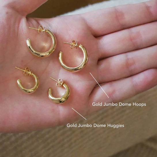 EF-Collection Gold Jumbo Dome Hoop Earrings in yellow gold on models hand comparing the size of the huggies