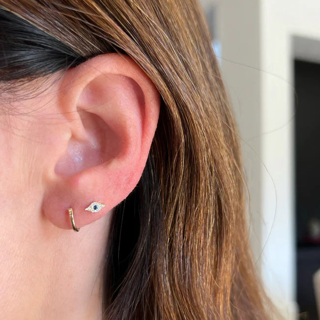 Single EF Collection Gold Mini Huggie Earring in yellow gold styled on models ear.