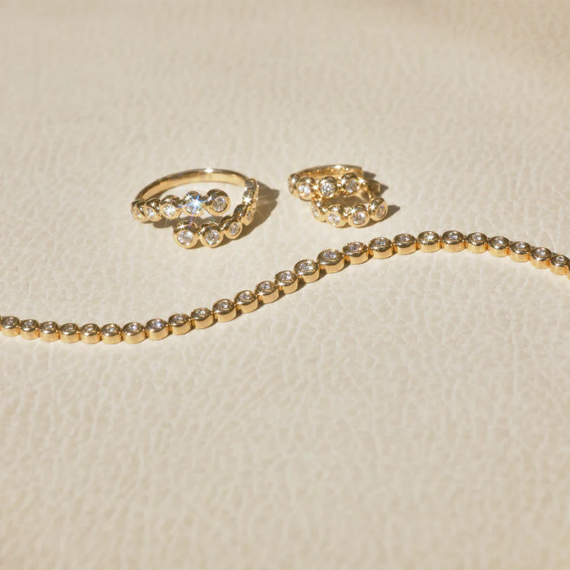 Product shot of EF-Collection Graduated Diamond Collection in yellow gold on leather background