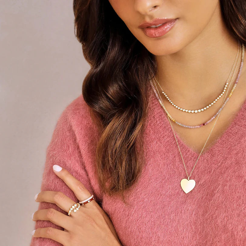 EF Collection Graduated Diamond Pillow Necklace in yellow gold styled on models neck with pink sweater.