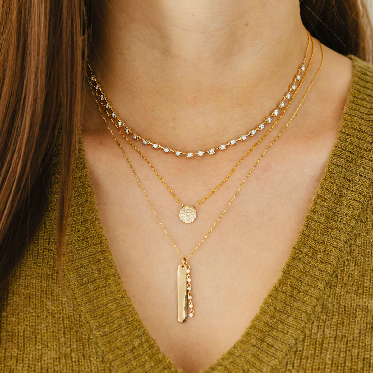 close up of of Dana Rebecca Designs Lauren Joy Medium Disc Necklace in Yellow Gold layered with other necklaces