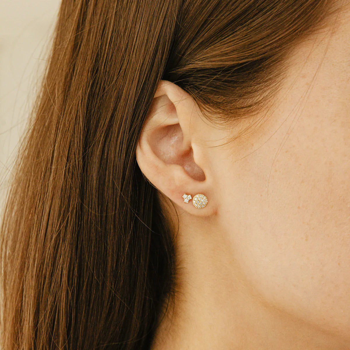 close up of Lauren Joy Mini Disc Studs in Yellow Gold styled with other studs on model's ear