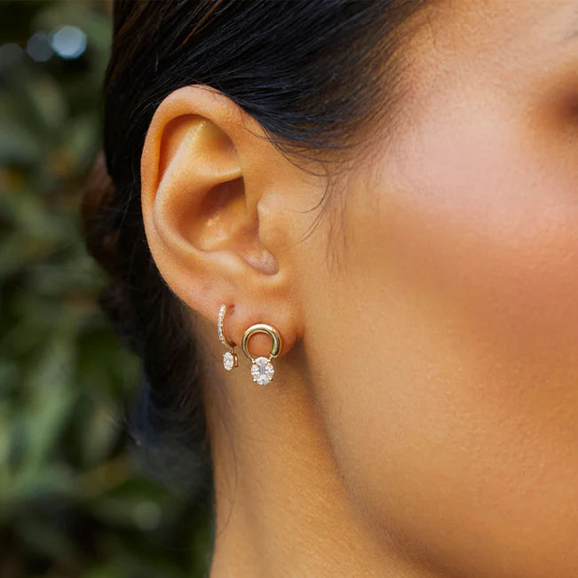 EF Collection Oval Drop Diamond Mini Huggie Earring in yellow gold styled on models ear.