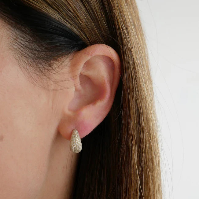 Single EF Collection Pavé Diamond Jumbo Dome Huggie Earrings in yellow gold on models ear.