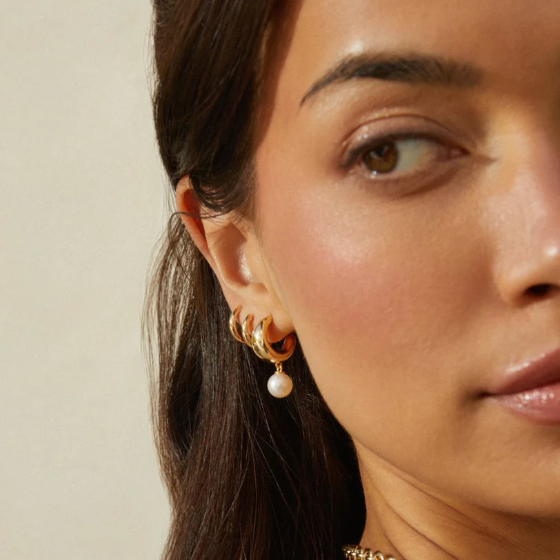 EF Collection Pearl Drop Gold Jumbo Dome Huggie Earrings in yellow gold on models ear.