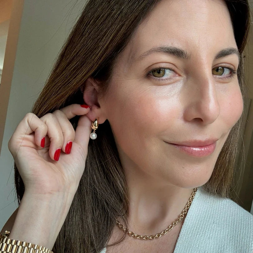 Single EF Collection Pearl Drop Gold Jumbo Dome Huggie Earrings in yellow gold styled on Emily's ear.