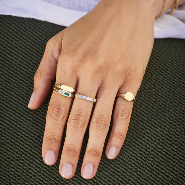 EF Collection Prong Set Diamond Baguette Ring in yellow gold styled on model’s finger with gold signet ring.
