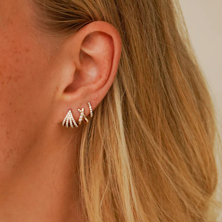 Dana Rebecca Designs Sarah Leah Four Burst Huggies in yellow gold styled on models ear with two diamond huggies