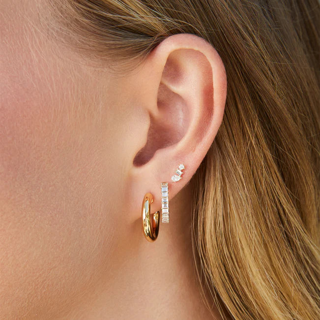 EF Collection Sasha Hoop Earrings in yellow gold layered on models ear as a statement piece.