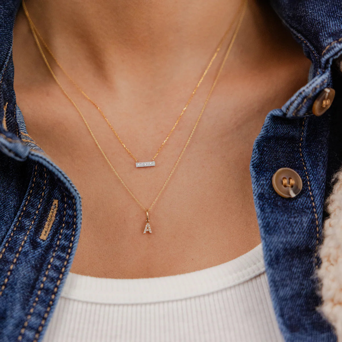 Close up of Dana Rebecca Designs Sylvie Rose Bar necklace Yellow Gold layered with an initial necklace