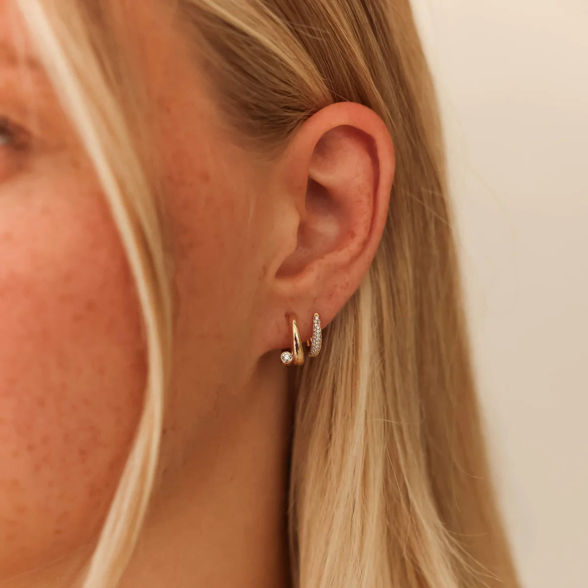 Dana Rebecca Designs Taylor Elaine Bypass Hoop styled in yellow gold on blonde model with white background.