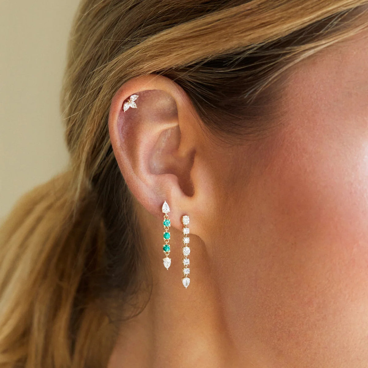 Close up of models ear wearing EF-Collection Triple Diamond Mini Pear Stud Earrings in yellow gold