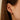 closeup of dana rebecca designs yellow gold diamond mini huggie staked in an ear