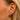 closeup of dana rebecca designs yellow gold diamond mini huggie staked in an ear with other styles of huggies