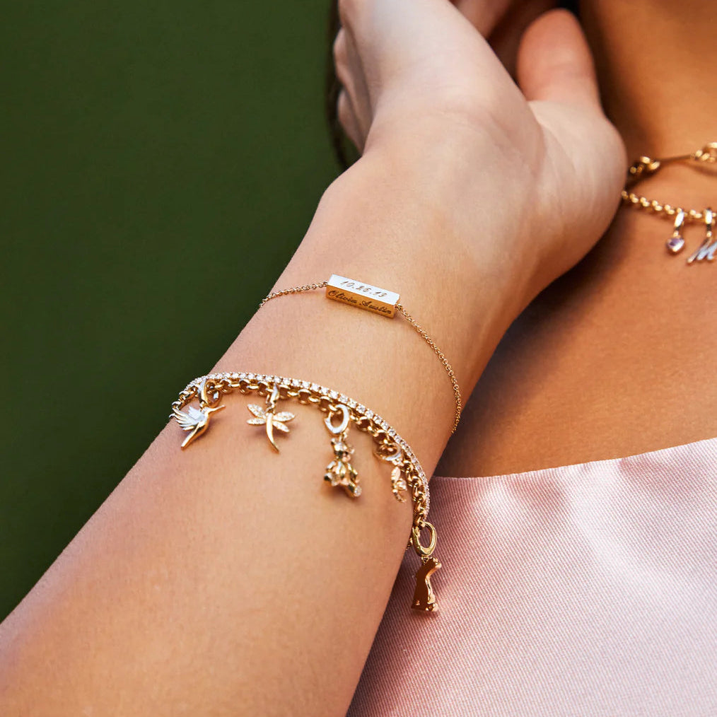 close-up of EF-Collection Diamond Teddy Clip Charm in yellow gold clipped onto a bracelet chain on a model's wrist.