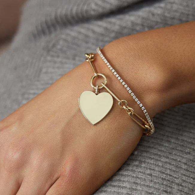 EF Collection Gold Jumbo Heart Charm Bracelet in yellow gold on models wrist styled with diamond tennis bracelet. 