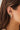 Ef collection Single Jumbo Prong Set Emerald Mini Huggie Earrings in yellow gold on models ear styled with different hoops. 