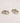 Pair of gold hoop earrings with diamond accents on a light marble background