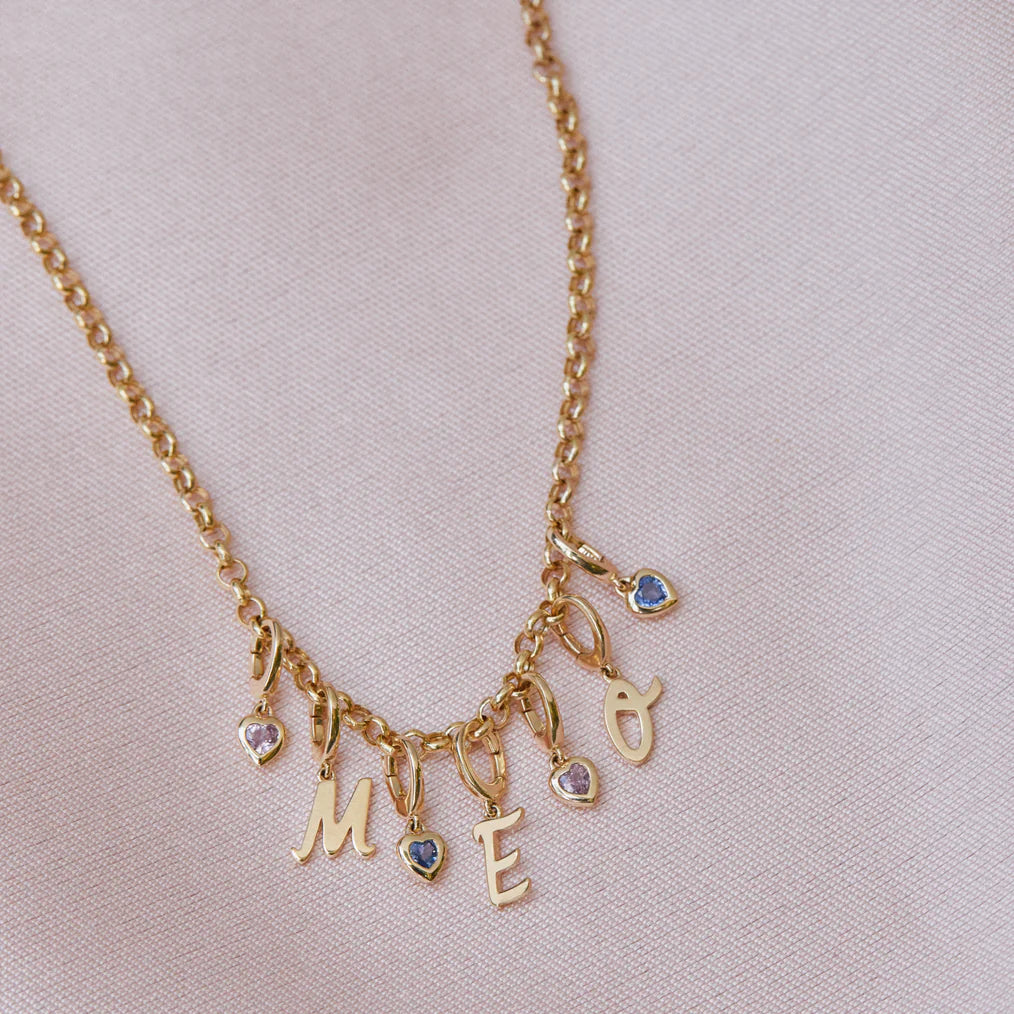 image of EF-Collection Mini Pink Sapphire Heart Clip Charm in rose gold in a chain on a baby pink background. 