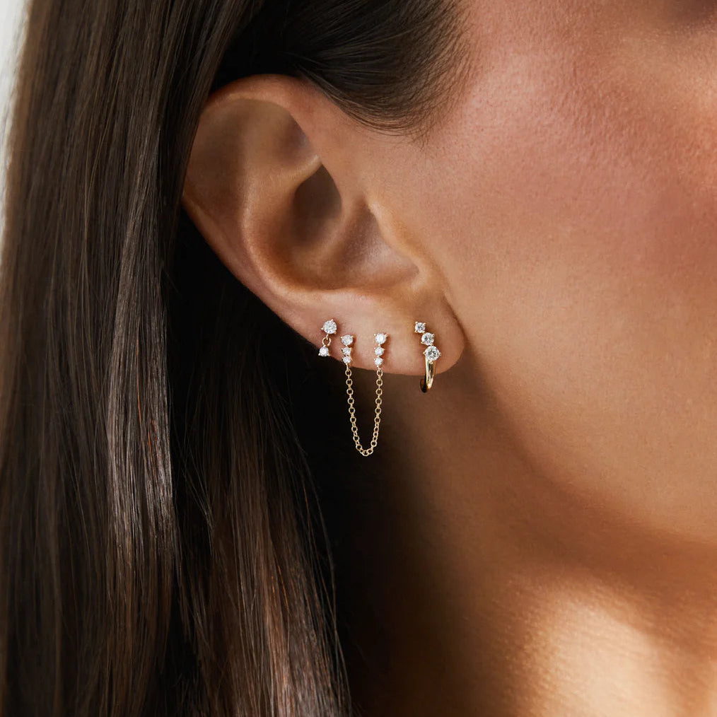 close-up of EF-Collection Diamond Leila Huggie Earrings on a model's ear. 