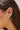 Close-up of an ear wearing gold hoop earrings with small diamond studs.
