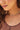 Close-up of a woman wearing multiple necklaces with a soft focus on her face and hair.