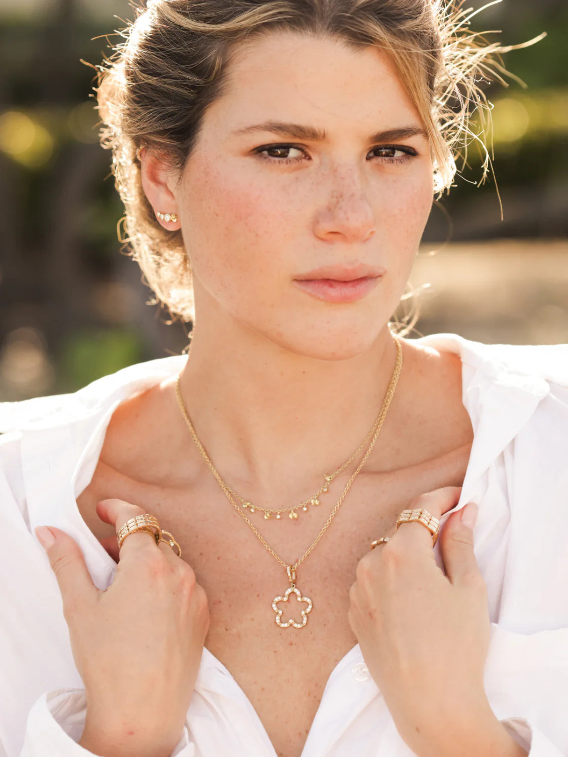 model shot of Onirikka Glimmer Diamond Flower Charm in 18k yellow gold on a yellow gold necklace. 