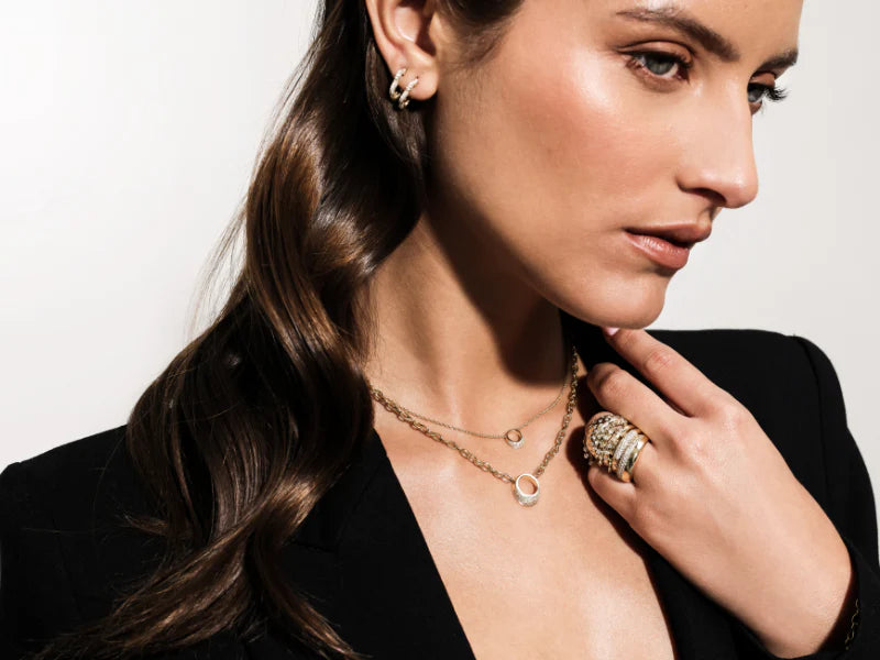 Shot of a model wearing Onirikka Half Pavé Florette Hoops in satin 14k yellow gold