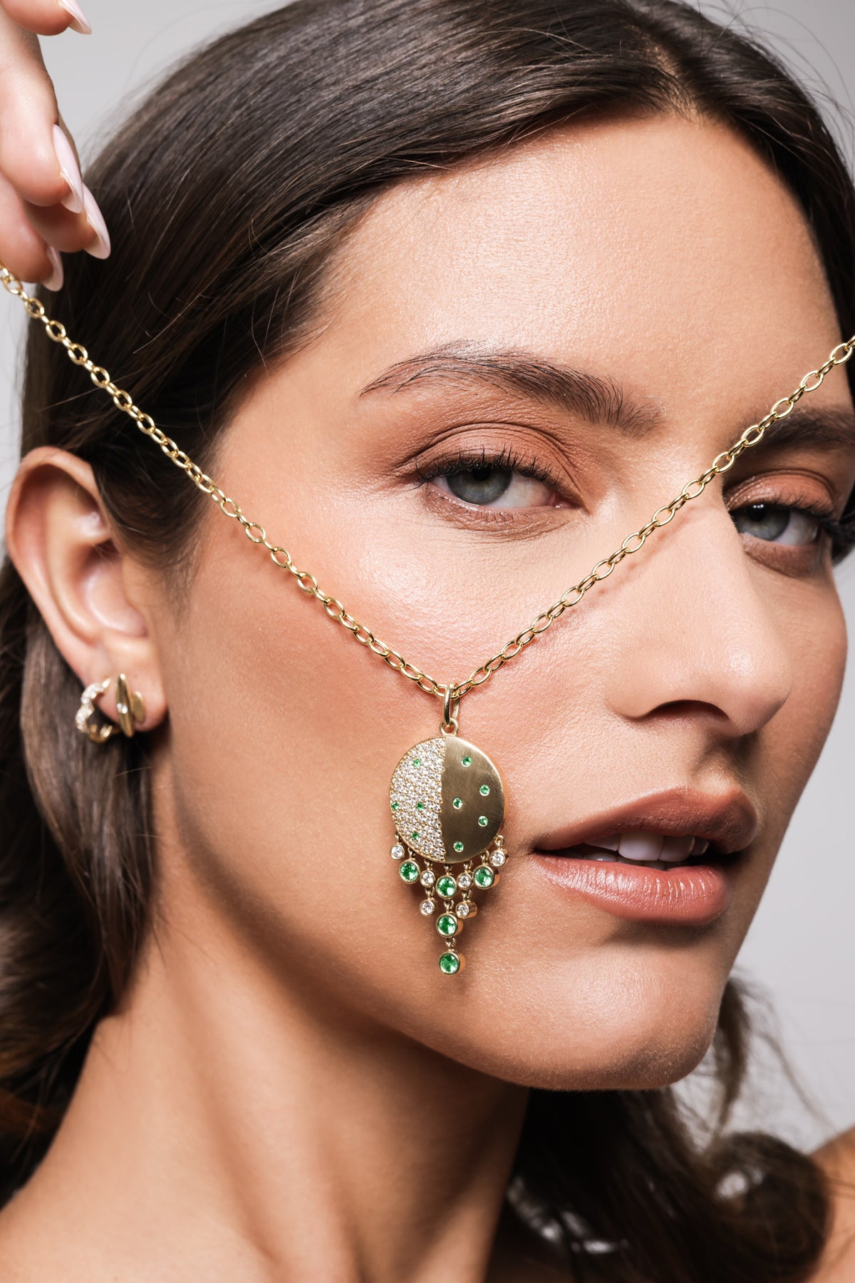 Close up of Onirikka Grand Caviar Medallion in yellow gold, diamonds and emeralds. 