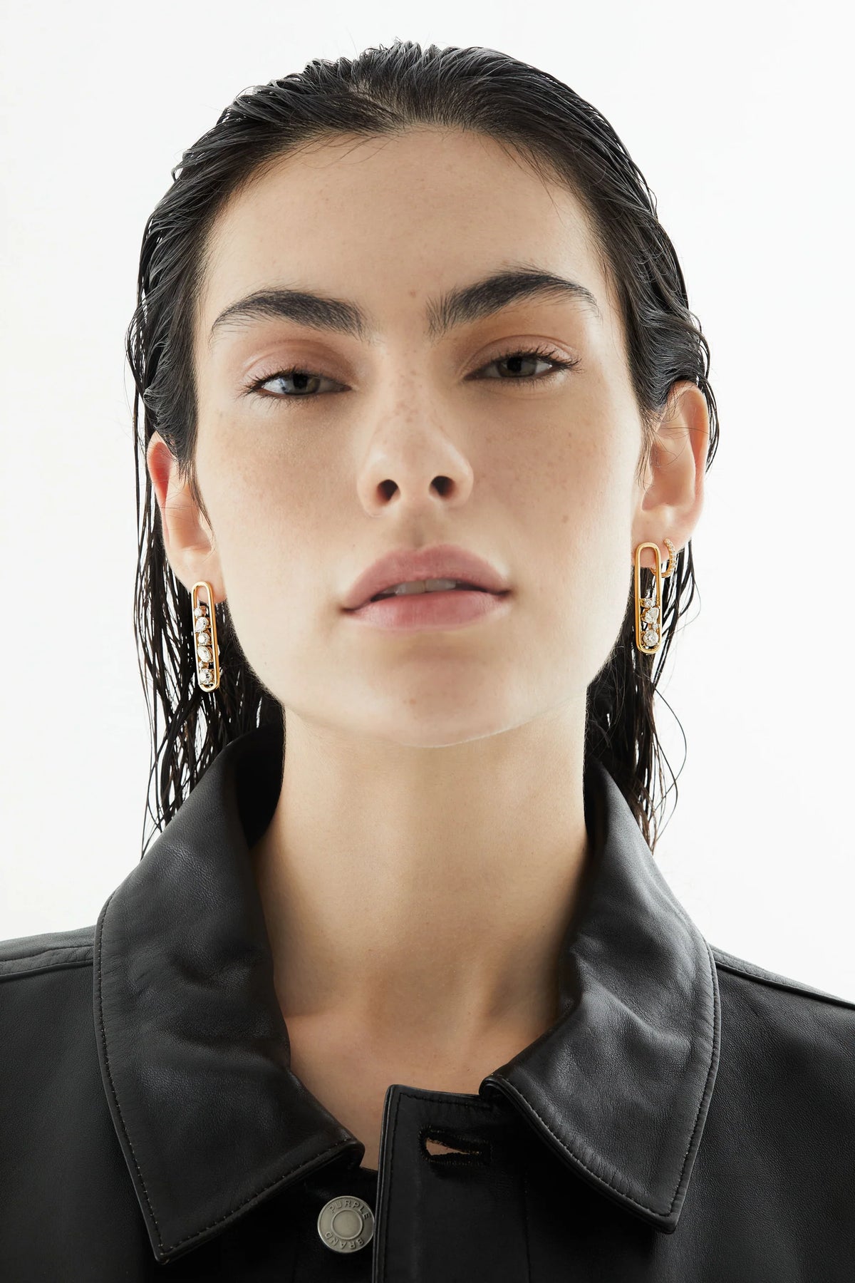 Woman wearing Rosario Navia Mara Drop Earrings in yellow gold and diamonds over a white background.