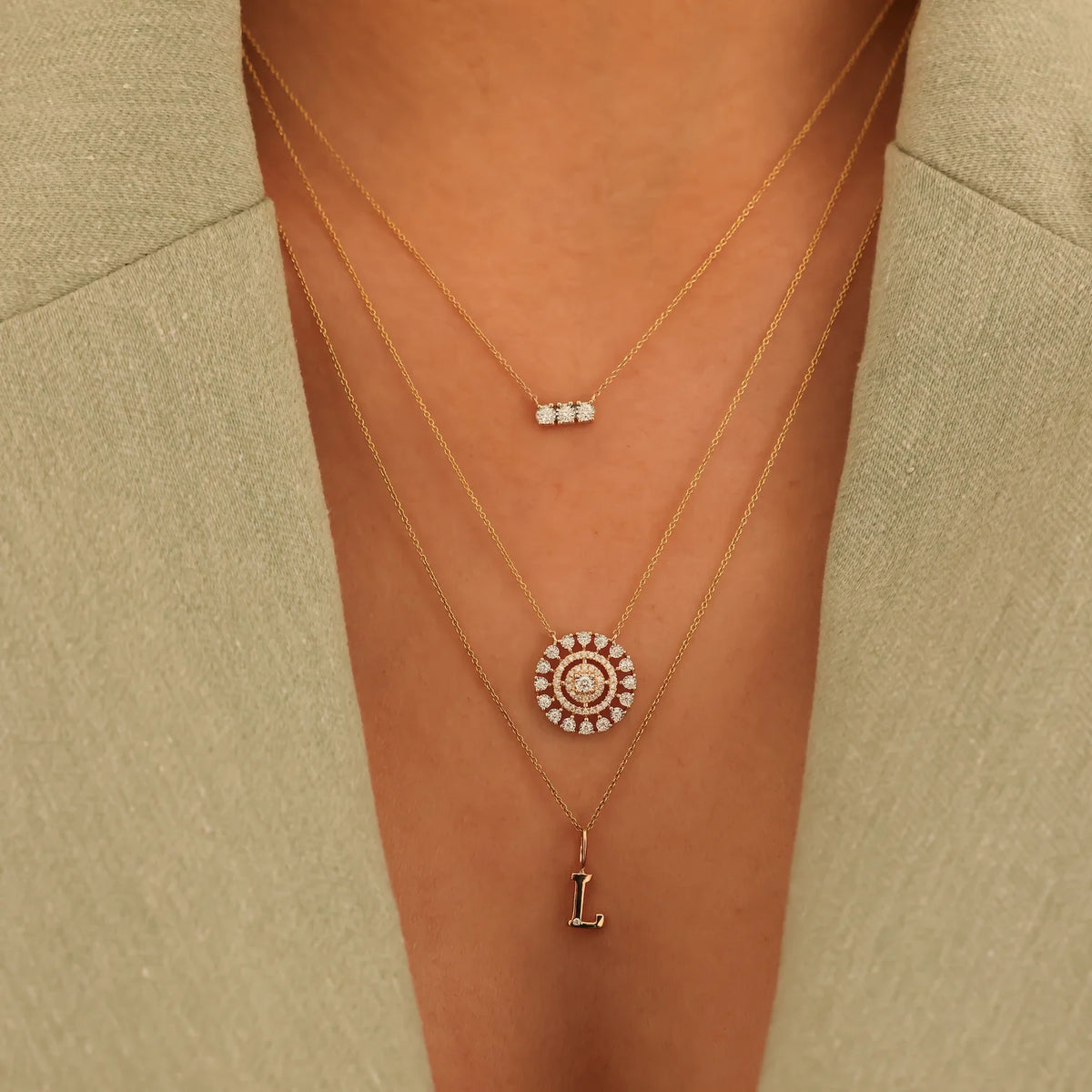 Dana Rebecca Designs Ava Bea Medallion Necklace in yellow gold on models neck with gold letter charm with a single diamond 