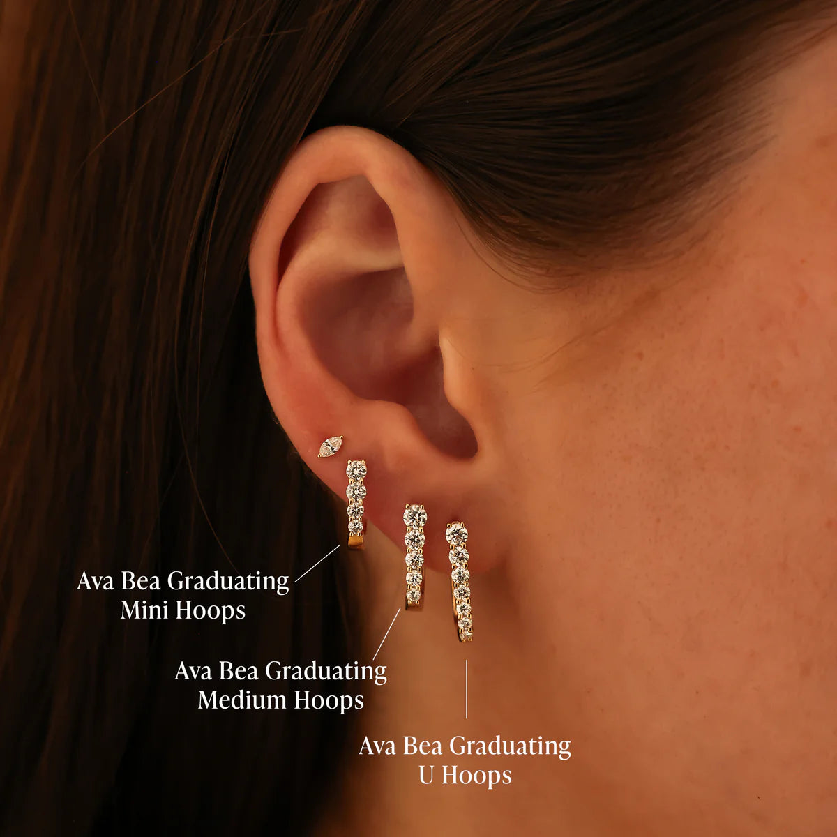 close up of Ava Bea Mini Graduating Hoop in yellow Gold styled on ear other U hoops