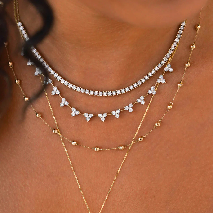Dana Rebecca Designs Ava Bea Tennis Necklace in yellow gold on models neck styled with other necklaces 