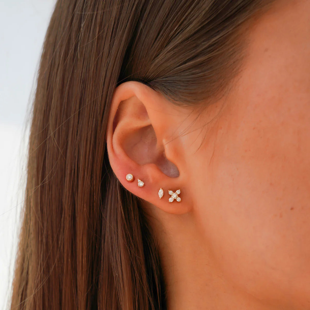 close up of Ava Bea X Studs in rose Gold stacked on model's ear